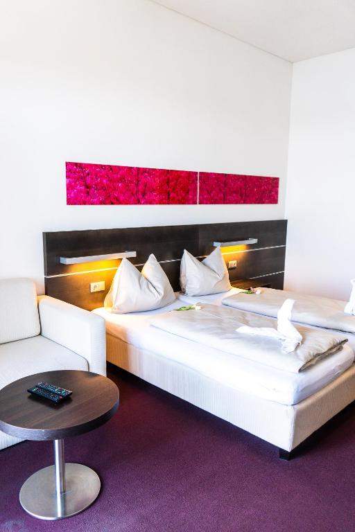 A bed or beds in a room at Neufeldersee Hotel & Restaurant