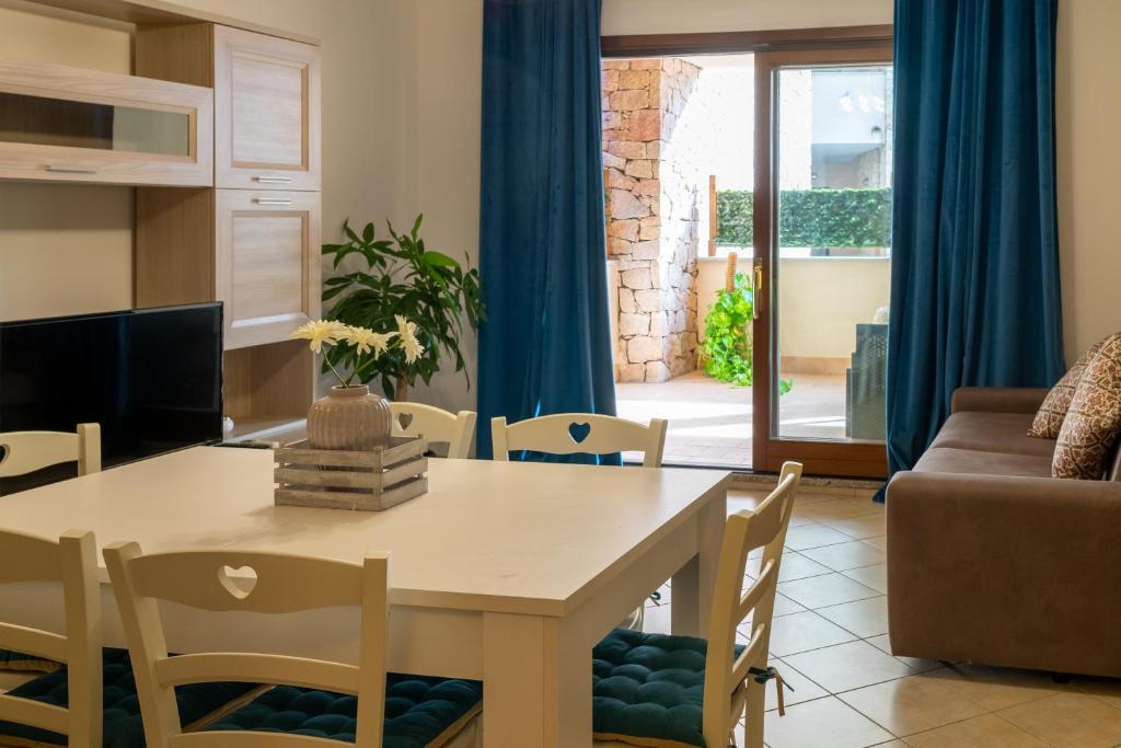 a dining room and living room with a table and chairs at Il Borgo Appartamenti in Olbia