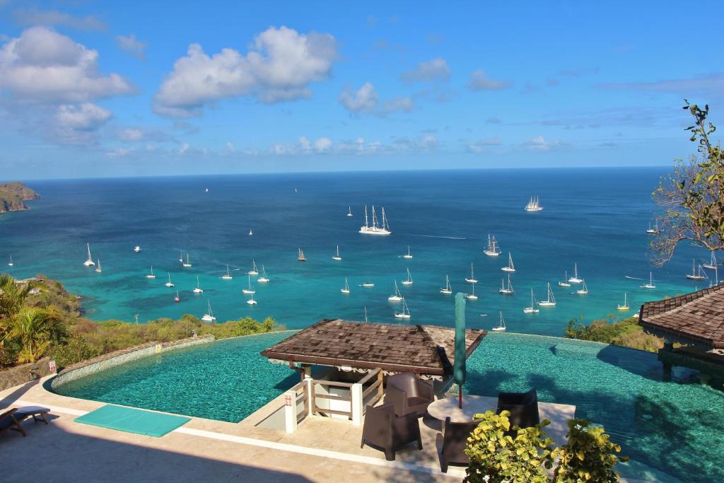 a pool with a view of the ocean and boats at Tropical Hideaway in Port Elizabeth