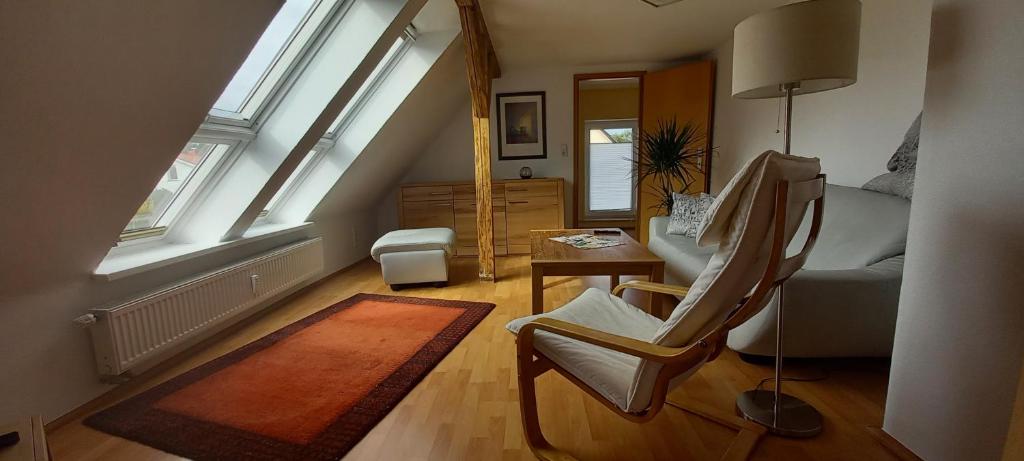 a living room with a chair and a table and windows at Ferienwohnung Vor den Toren Lübecks in Herrnburg