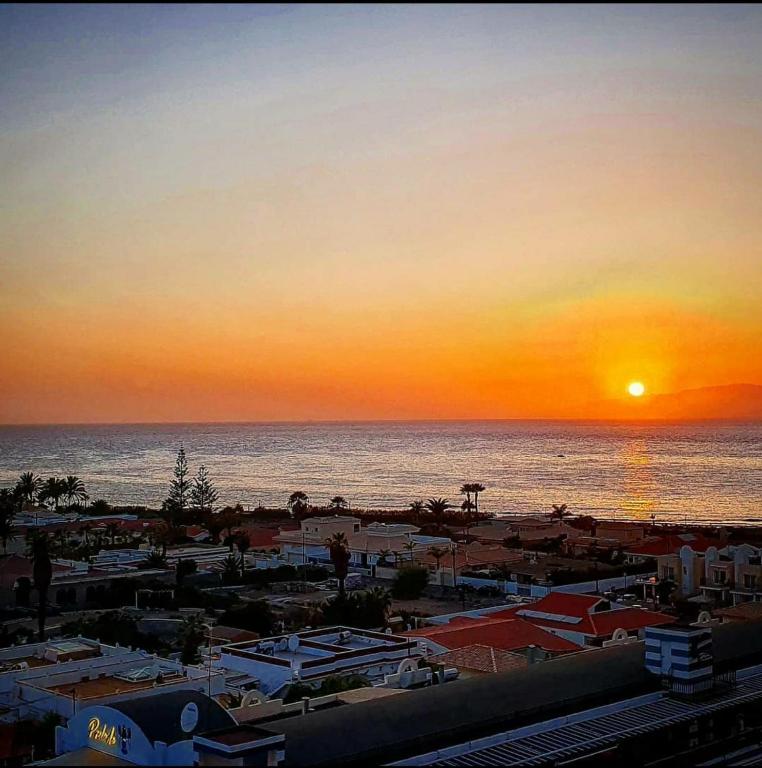 a view of a beach with the sun setting over the ocean at Apartment Royal Sunset Loggia in Palm-Mar