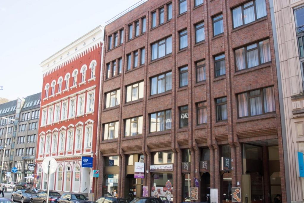 ein Backsteingebäude auf einer Stadtstraße mit vor der Tür geparkt in der Unterkunft Boardinghouse Rosenstraße in Hamburg