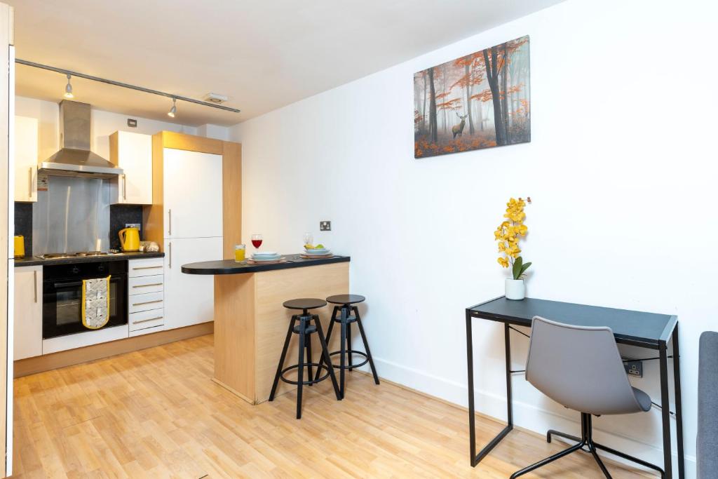 a kitchen with a table and stools in a room at Leicester Luxury Apartments - Eastgate in Leicester