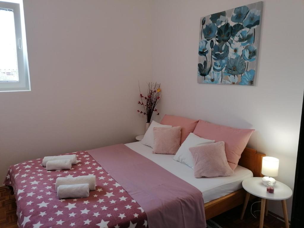 Habitación pequeña con cama con almohadas rosas. en Kuća za odmor Ana, en Ražanac