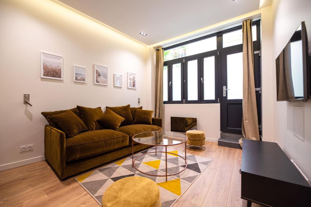 een woonkamer met een bank en een glazen tafel bij MBM - TERRAGE in Parijs