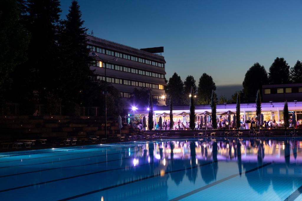 uma grande piscina de água em frente a um edifício à noite em Living Place Hotel em Villanova