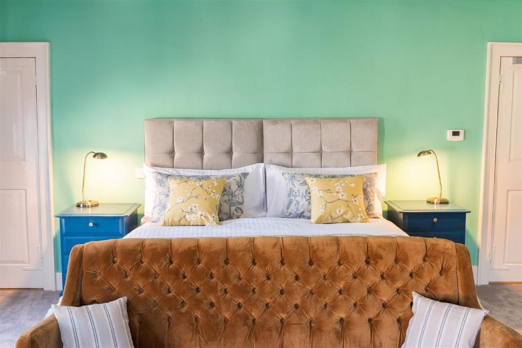una camera da letto con un grande letto con due comodini di The Boarding House a Halesworth