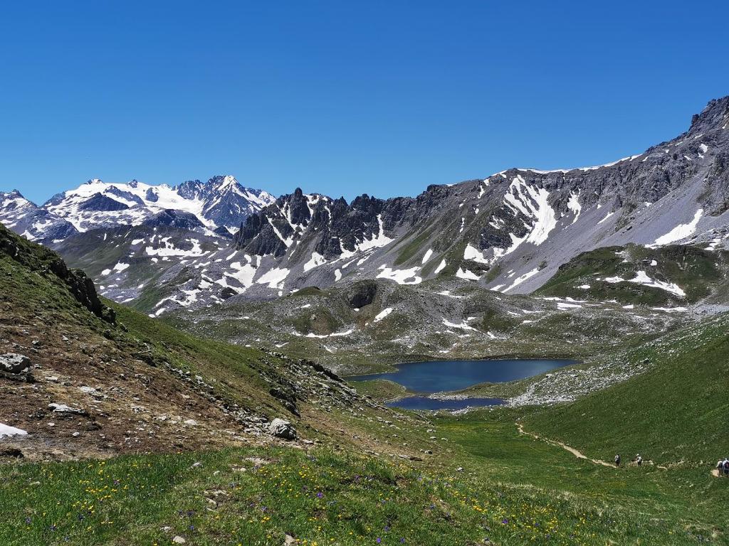a view of a snow covered mountain with a lake at Chalet Emilie in Courchevel