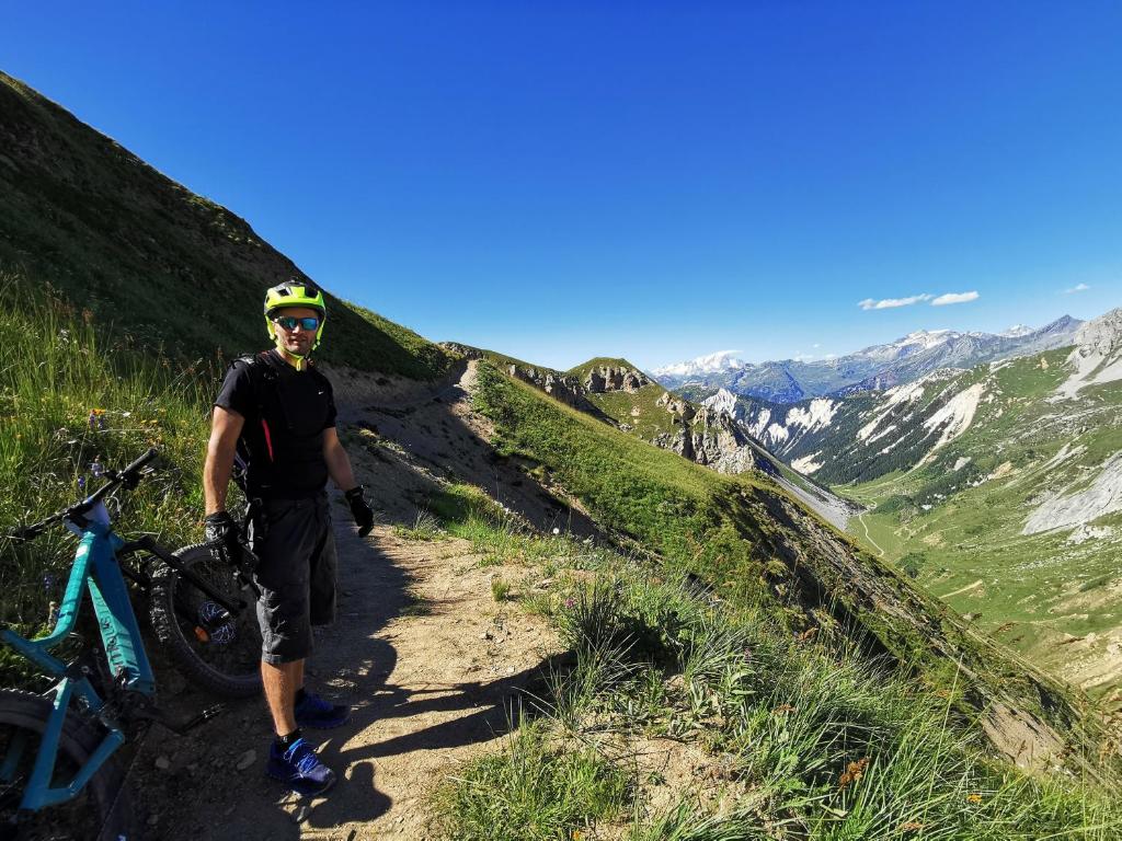 a man standing on a trail with a bike at Chalet Emilie in Courchevel