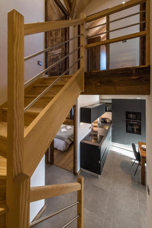 a staircase leading to the kitchen and dining room of a house at ODYSSEE A201 Vaste appartement en vieux bois sur les pistes, vue panoramique in La Toussuire