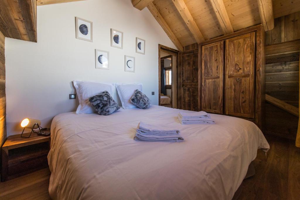 a bedroom with a bed with blue towels on it at ODYSSEE A201 Vaste appartement en vieux bois sur les pistes, vue panoramique in La Toussuire