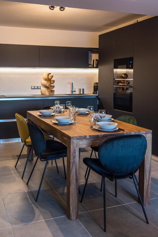 a dining room with a wooden table and chairs at ODYSSEE A201 Vaste appartement en vieux bois sur les pistes, vue panoramique in La Toussuire