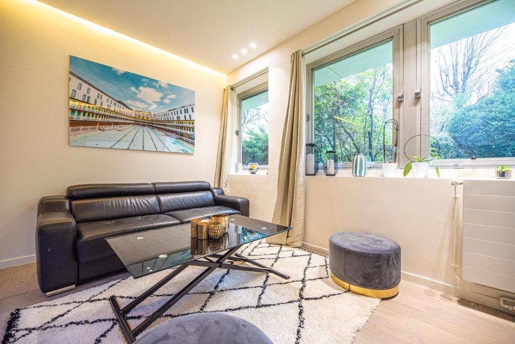 uma sala de estar com um sofá de couro e uma mesa em MBM - LA TOUR em Paris