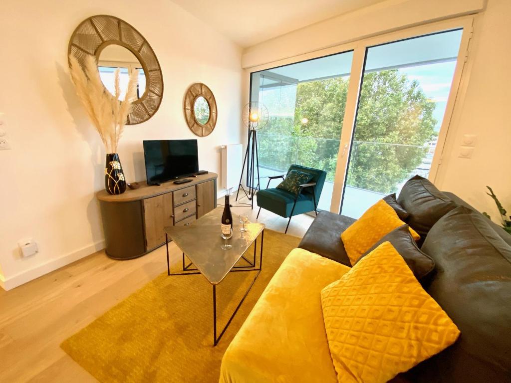 a living room with a couch and a table at Presqu'île de Caen, Terrasse & Parking in Caen