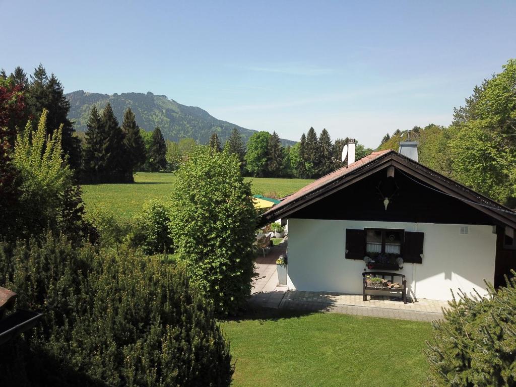 a small white building with a stove in a yard at Ferienhaus BERGEBLICK 5S in Bad Tölz