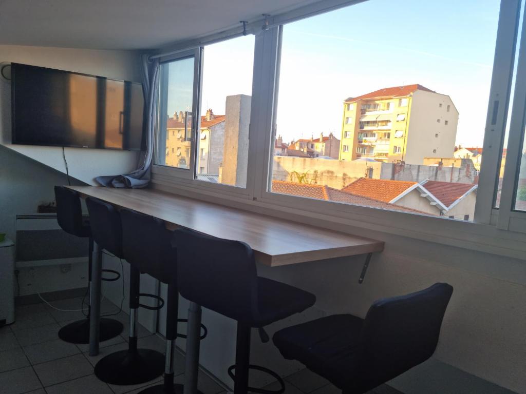 mesa y sillas en una habitación con ventana grande en T2 Belle vue renové centre ville en Valence