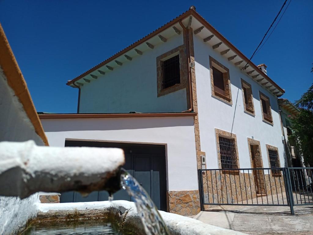 ein schneebedecktes Haus vor einem Haus in der Unterkunft Alojamiento Rural El Ojuelo in El Ojuelo