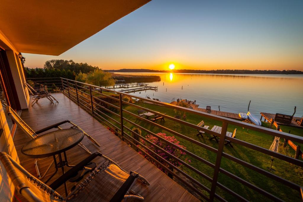 a balcony with a view of a lake at sunset at Willa Tałty in Mikołajki