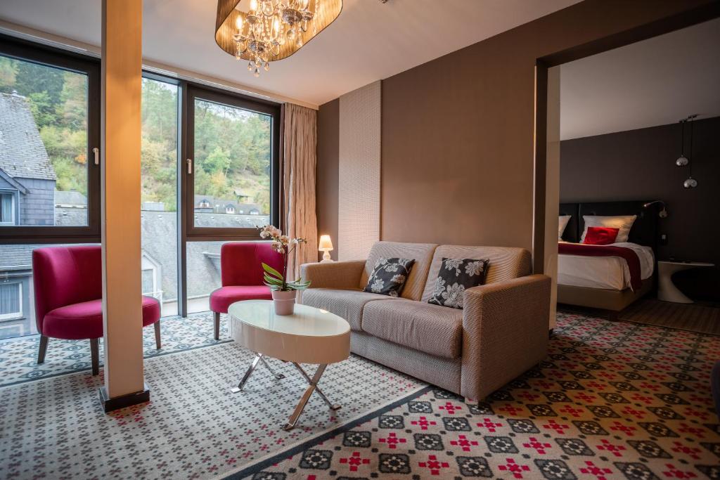 ein Wohnzimmer mit einem Sofa und einem Bett in der Unterkunft Le Clervaux Boutique Hotel & Spa in Clerf