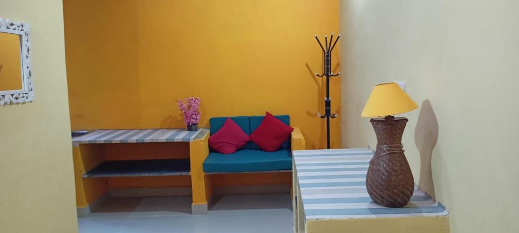een kamer met een bank en een tafel met een lamp bij Red Monkeys Hostel in Arambol