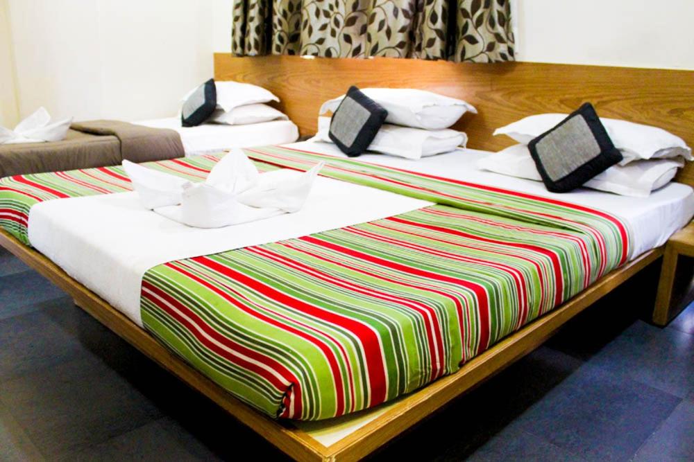 Postel nebo postele na pokoji v ubytování Hotel Shradha Saburi Palace