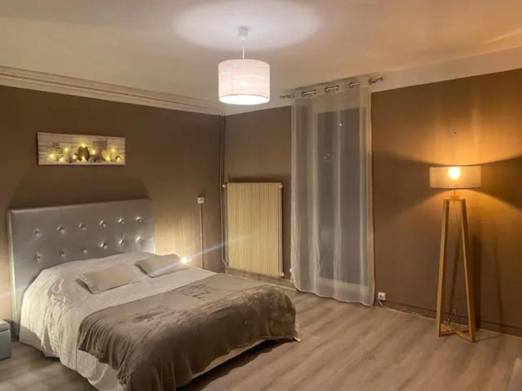 um quarto com uma cama grande e um candeeiro em L'ÉCLUSE TERRASSE PARKING GRATUIT Home-One em Dole