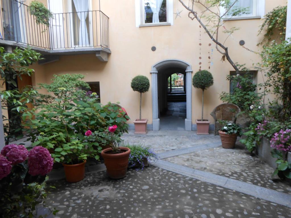 un cortile interno di una casa con piante in vaso di Casa De Giorgis ad Aosta