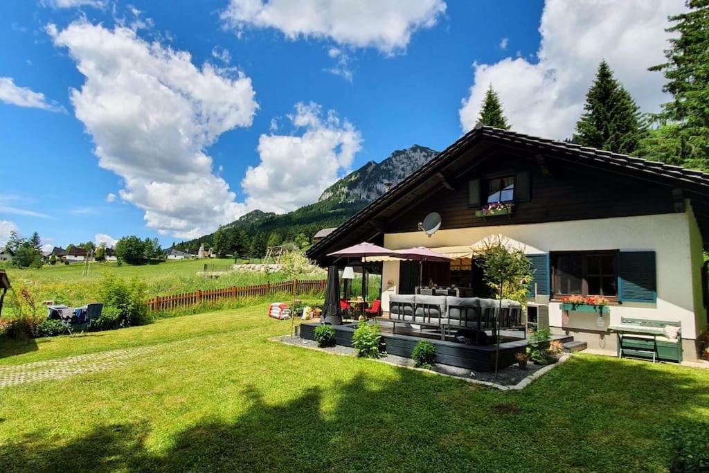 ein Haus auf einem Feld mit einem grünen Hof in der Unterkunft Alpenchalet im Steirischen Salzkammergut in Tauplitz