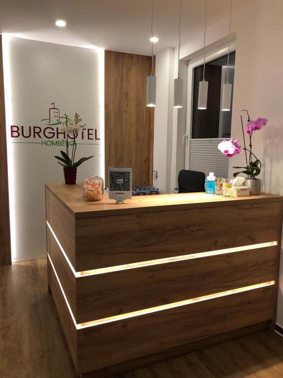recepción del hotel con encimera de madera en Burghotel Homberg, en Homberg