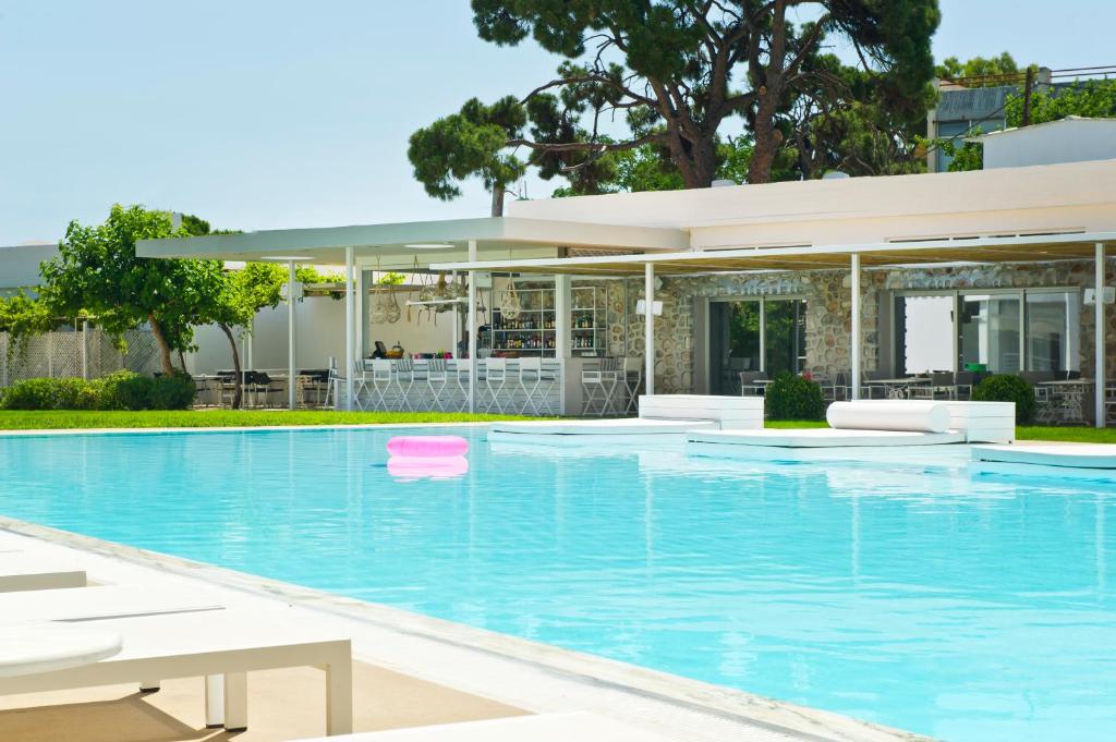 a swimming pool in front of a house at Marathon Beach Resort in Nea Makri