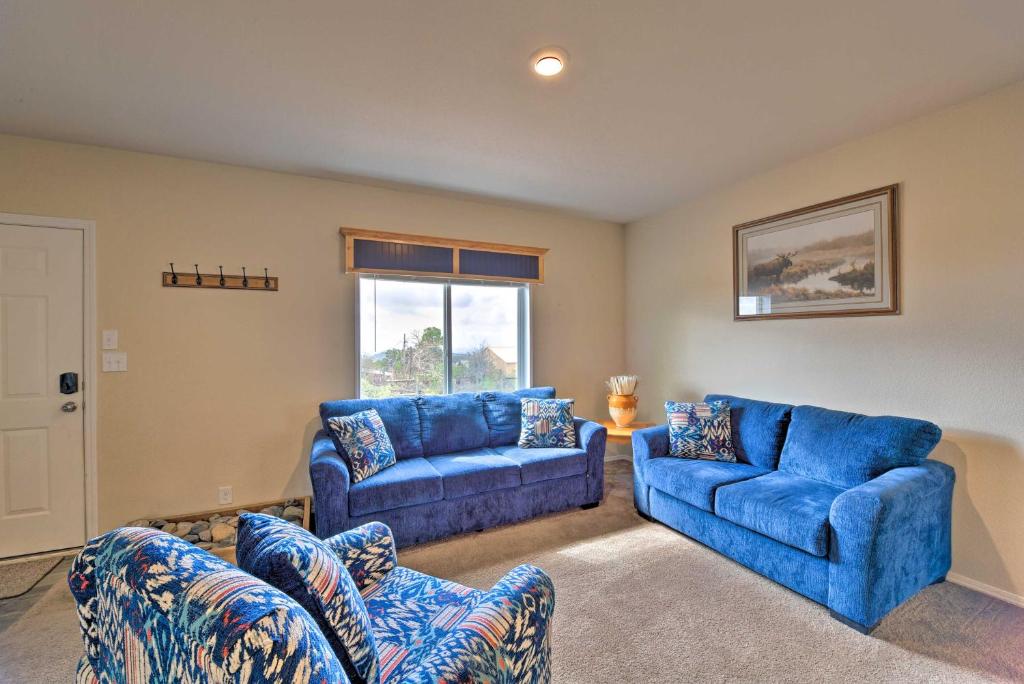 sala de estar con sofás azules y ventana en Cedaredge Hideaway with Grill and Mountain Views! en Cedaredge