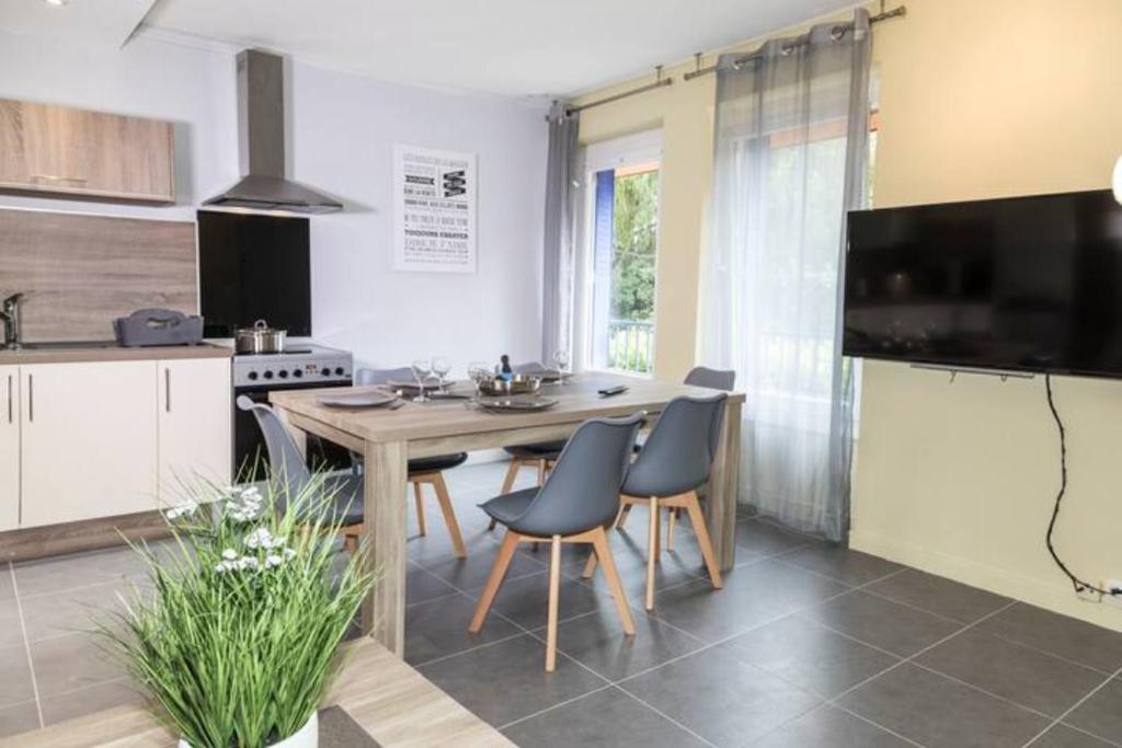 - une cuisine avec une table et des chaises en bois dans l'établissement LA COMMANDERIE JARDIN PARKING Home-One, à Dole