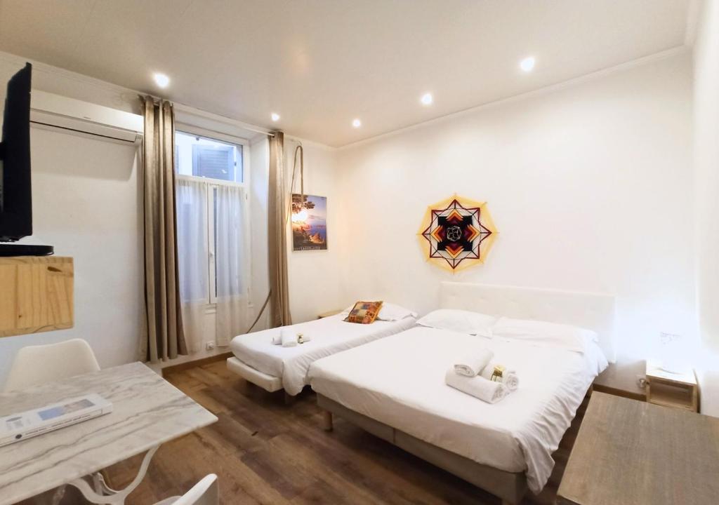 カンヌにあるViva Riviera - 19 rue des Frères Pradignacのベッド2台とテーブルが備わるホテルルームです。