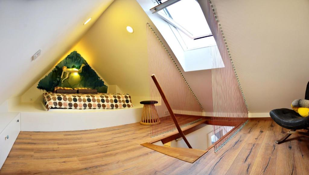 a room with a staircase in the attic with a window at Jono Apartment in Klaipėda