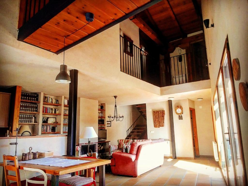 Casa Rural el Pajar de Tenzuela في Pelayos del Arroyo: غرفة معيشة مع طاولة وأريكة