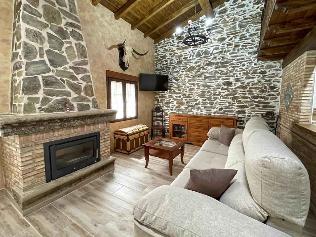- un salon avec un canapé et une cheminée dans l'établissement Recuerdos de Monfragüe, à Malpartida de Plasencia