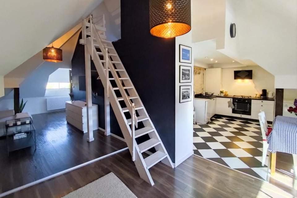 a living room with a staircase and a kitchen at Apartamenty Dom Kifnera in Kazimierz Dolny