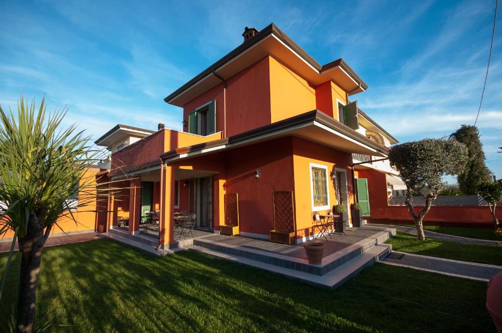 una casa de color rojo y amarillo en I Frutteti "affitta camere", en Lido di Camaiore