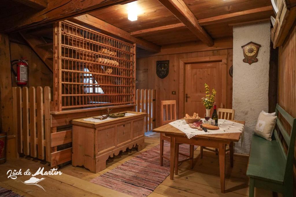 een eetkamer met een tafel en een houten kamer bij Lüch de Martin in La Valle
