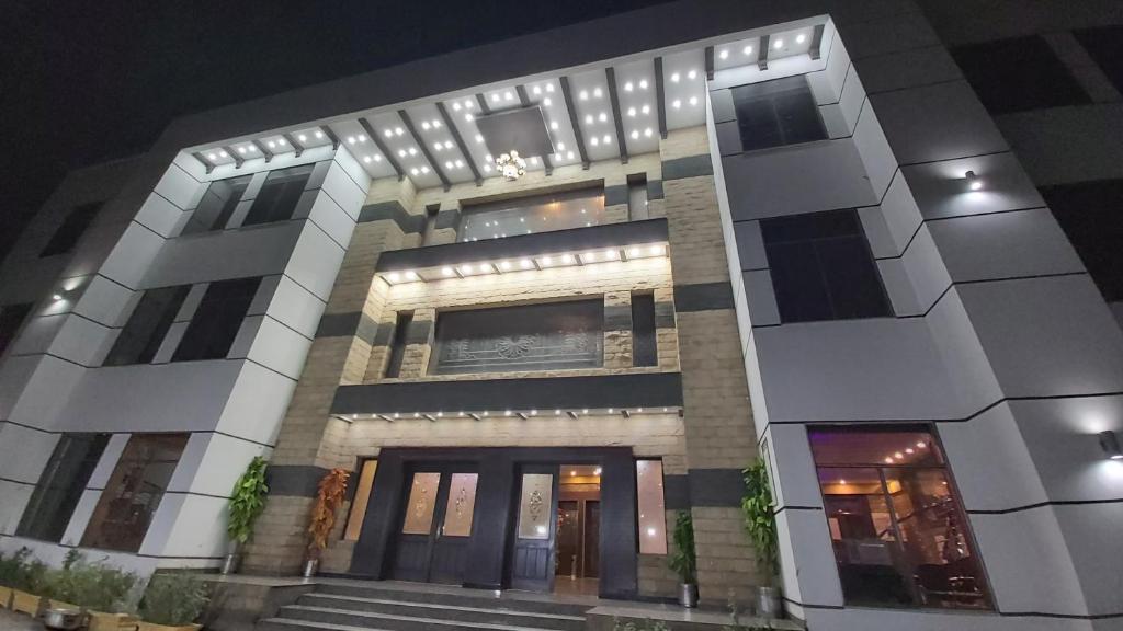a large white building with stairs in front of it at Royaute Luxury Hotel Sialkot in Sialkot