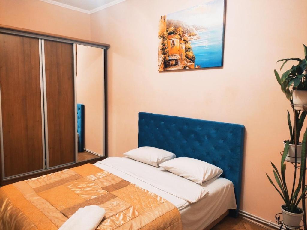 a bedroom with a bed with a blue head board at Lviv's Prospekt Shevchenka Apartments in Lviv