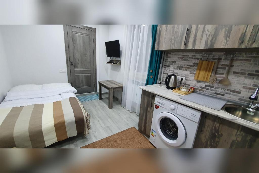 uma pequena cozinha com uma cama e uma máquina de lavar roupa em Yerevan Studio em Yerevan