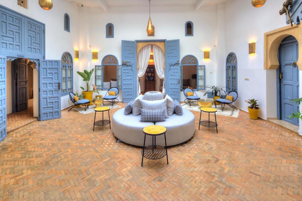 een woonkamer met een bank en tafels en stoelen bij Riad Amaris in Rabat