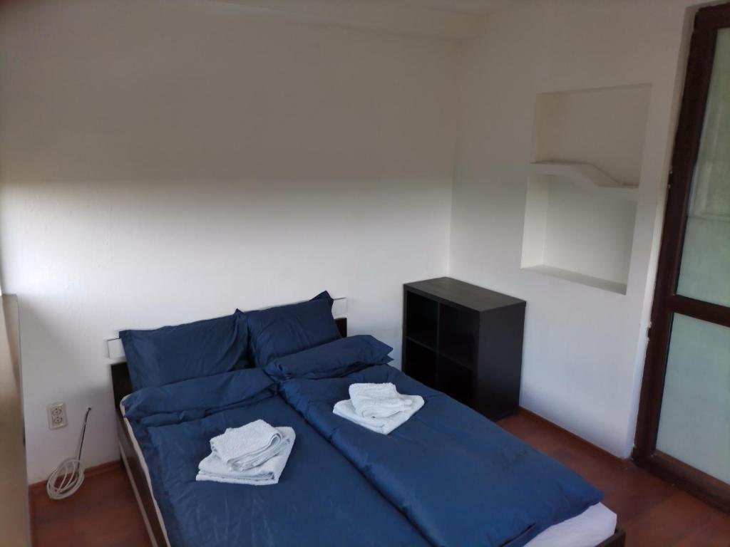 a bedroom with a blue bed with blue sheets and towels at Magurele Forest in Măgurele