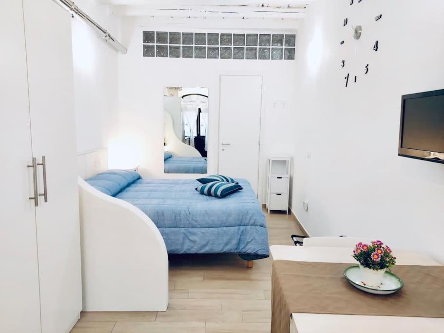 カリアリにあるIl Tesorino di Castello - Cagliari Centro Storicoのベッドルーム(青いベッド1台付)、リビングルーム