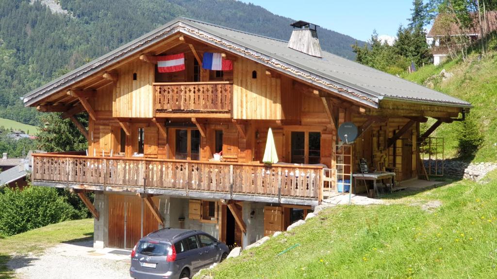 a large wooden house with a car parked in front at Le Grossglockner in Les Contamines-Montjoie