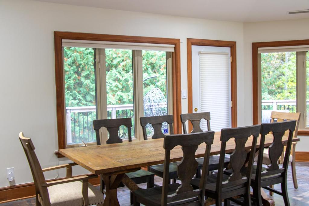 a dining room with a wooden table and chairs at Fairy Bay Lakehouse in Huntsville