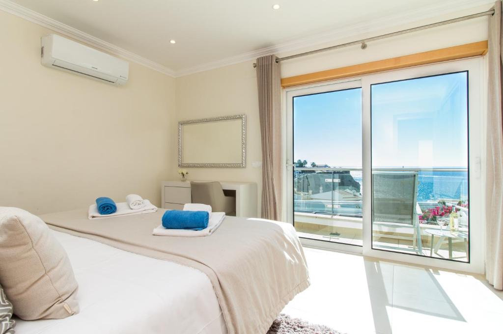 - une chambre avec un lit et une grande fenêtre dans l'établissement Panoramic Seaview Holiday Escape Carvoeiro Algarve, à Carvoeiro