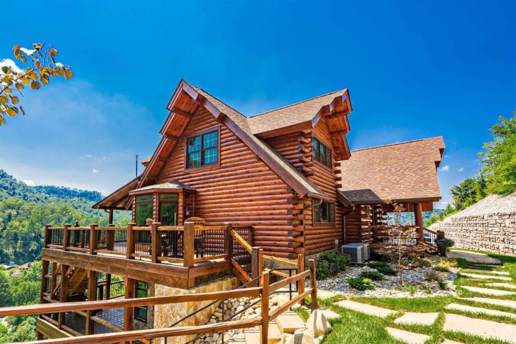 Cabaña de madera con terraza y techo en Roaring Fork Lodge, en Gatlinburg