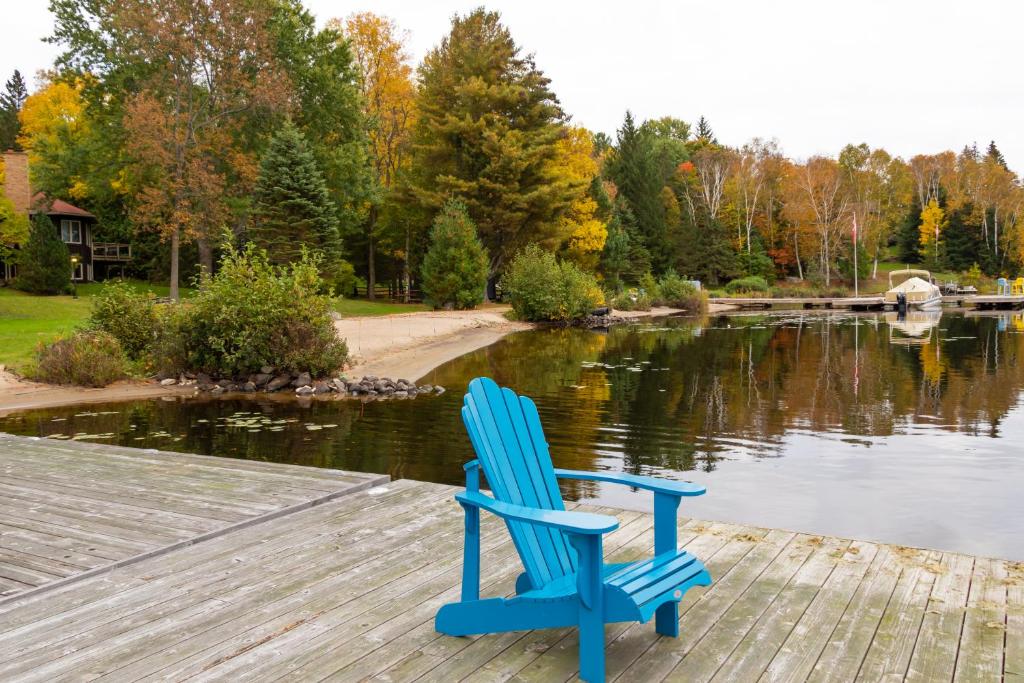 a blue chair sitting on a dock next to a lake at Fairy Bay Lakehouse in Huntsville